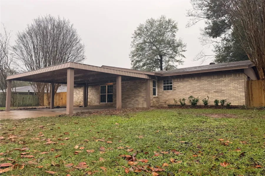 View of front of property with brick siding and an attached carport