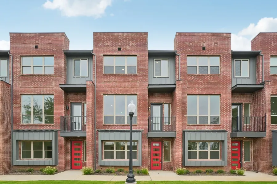 View of front of home featuring board and batten siding, a balcony, brick siding, and a residential view