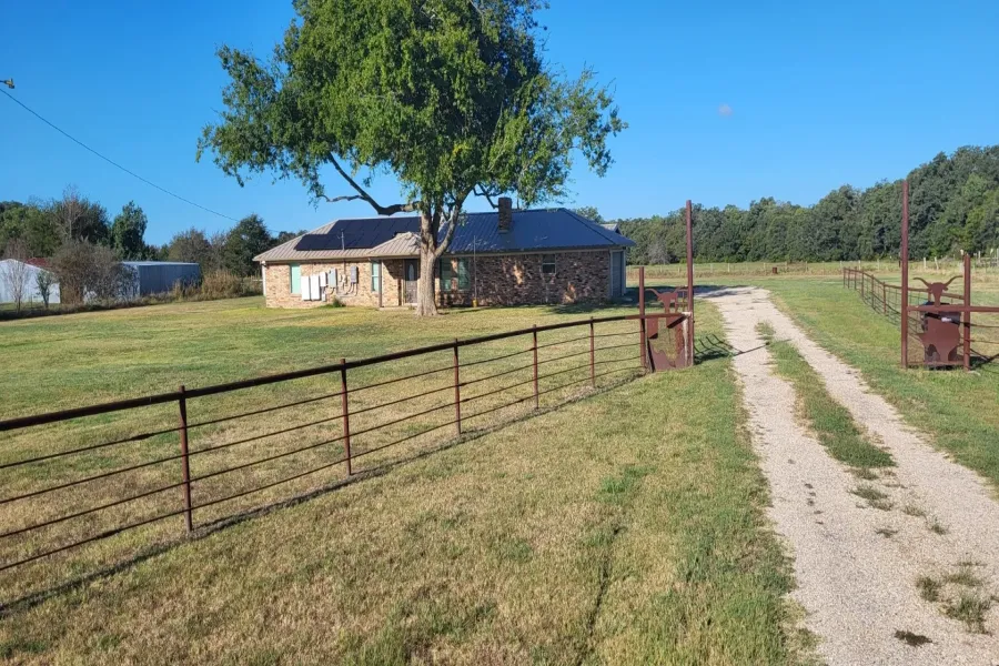 View of front facade featuring a front lawn, solar panels, and a rural view