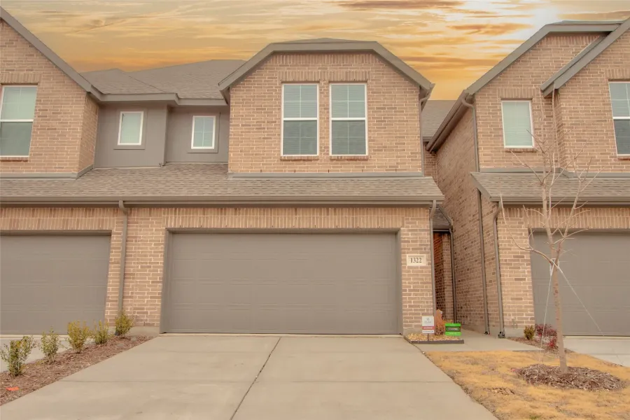 Craftsman house featuring a shingled roof, driveway, brick siding, and a garage