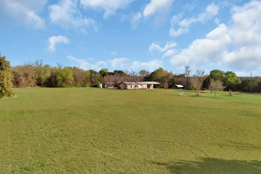 View of grassy yard with view of wooded area and view of golf course