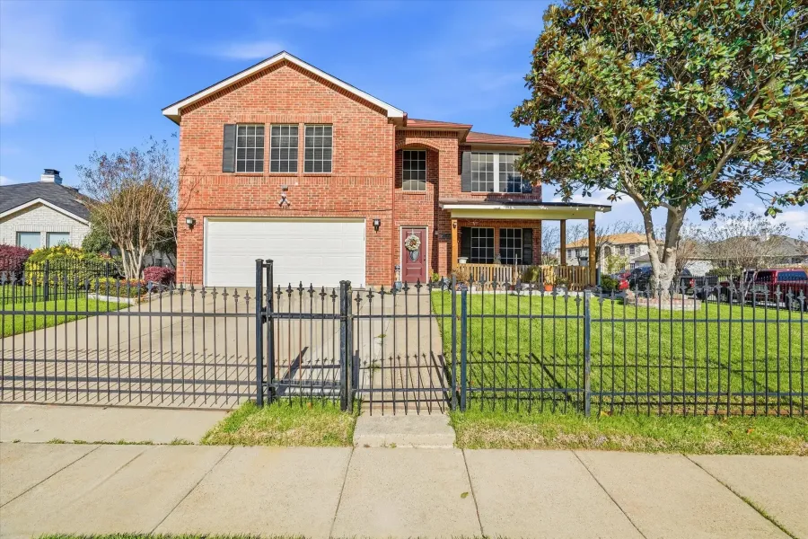 Traditional home with brick siding, a garage, a porch, and concrete driveway