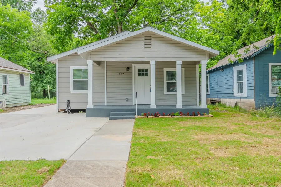 Bungalow with a porch and a front lawn