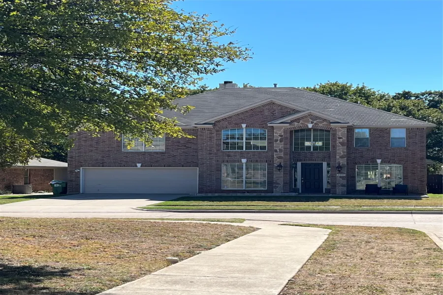 View of front of home featuring a garage, roof with shingles, a front yard, and concrete driveway
