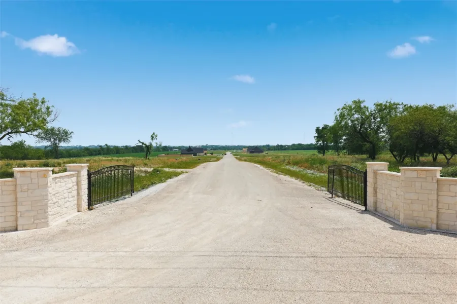 Gated entrance featuring stone columns and wrought iron gates