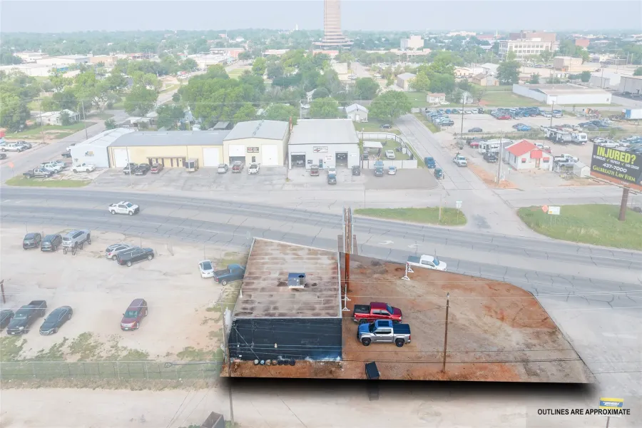 Commercial property featuring a flat roof and a partially paved lot