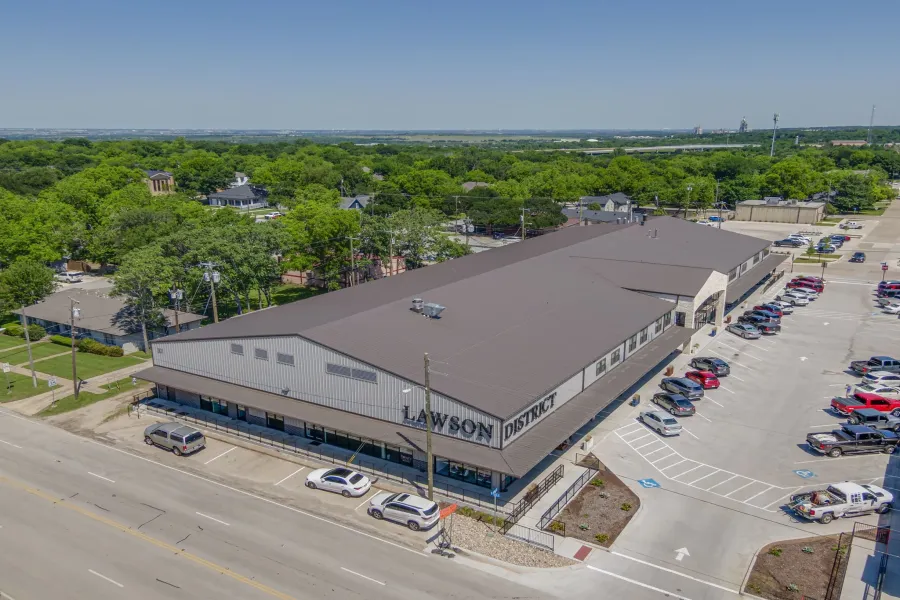 Commercial building with a metal roof and light-colored siding, featuring multiple storefronts