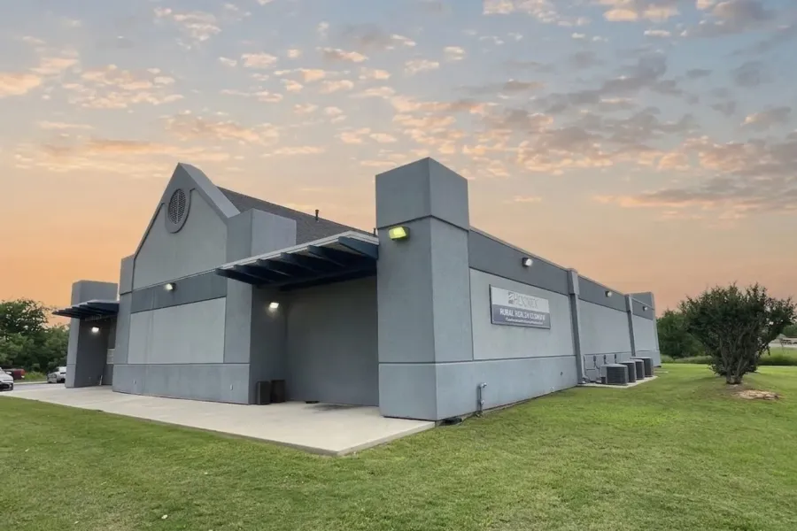 Modern commercial building featuring a pitched roofline, stucco exterior, and multiple external lighting fixtures