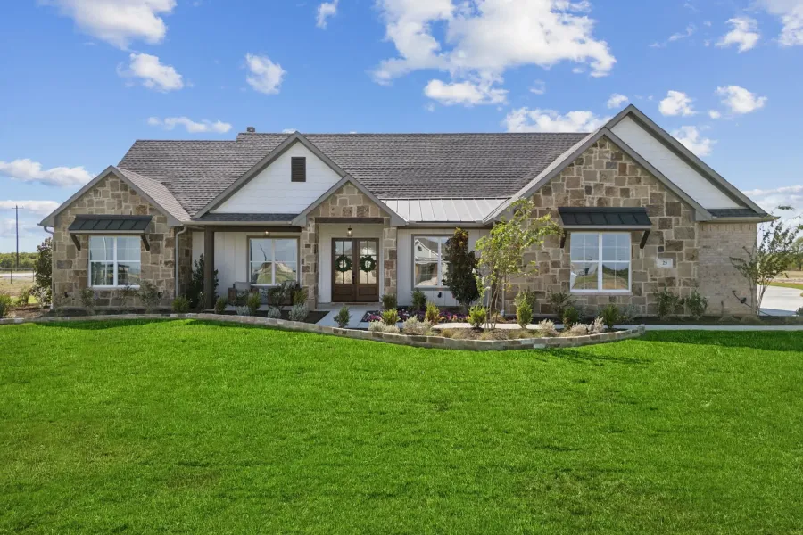 Stone and board-and-batten facade featuring a double-door entry, dark shingle roof, and coordinated window awnings