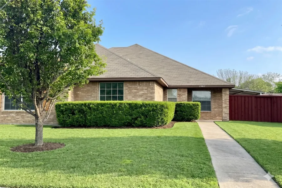 Brick exterior featuring a gabled roof and covered entry