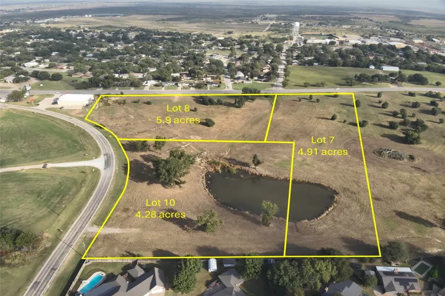 Aerial view of property and surrounding area featuring a large body of water and property parcel outlined