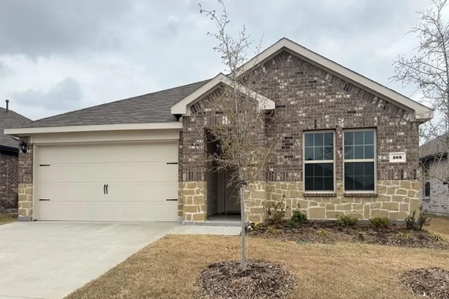 View of front of house featuring a garage, concrete driveway, and brick siding