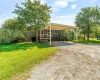 View of front of home featuring a front lawn, driveway, and a carport