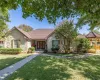 Ranch-style house featuring stone siding, a front yard, and a tile roof