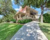 View of front of home with a balcony, a front lawn, a chimney, and a porch
