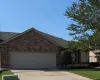 Ranch-style house featuring an attached garage, brick siding, driveway, and a shingled roof