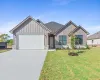 View of front of home featuring board and batten siding, an attached garage, concrete driveway, and a front lawn