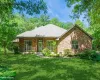 Single story home featuring brick siding, a front yard, a chimney, and a porch