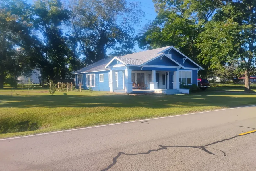 View of front of home featuring a porch, a front yard, and a metal roof