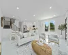 Living area with recessed lighting and stairway