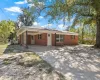 Ranch-style home with driveway, a carport, and brick siding
