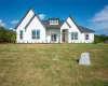 Modern farmhouse with a front lawn, board and batten siding, and roof with shingles