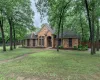 View of front of property featuring brick siding and roof with shingles