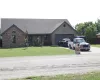 Single story home with brick siding, driveway, and a front yard