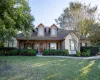 View of front of home with roof with shingles, a front yard, a porch, and brick siding