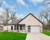 View of front of house with brick siding, an attached garage, concrete driveway, and a front lawn