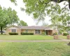 Ranch-style residence featuring a brick facade with white siding accents and a brown shingle roof