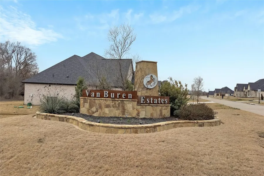Community / neighborhood sign featuring a yard