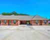 Ranch-style house featuring roof with shingles, brick siding, and concrete driveway