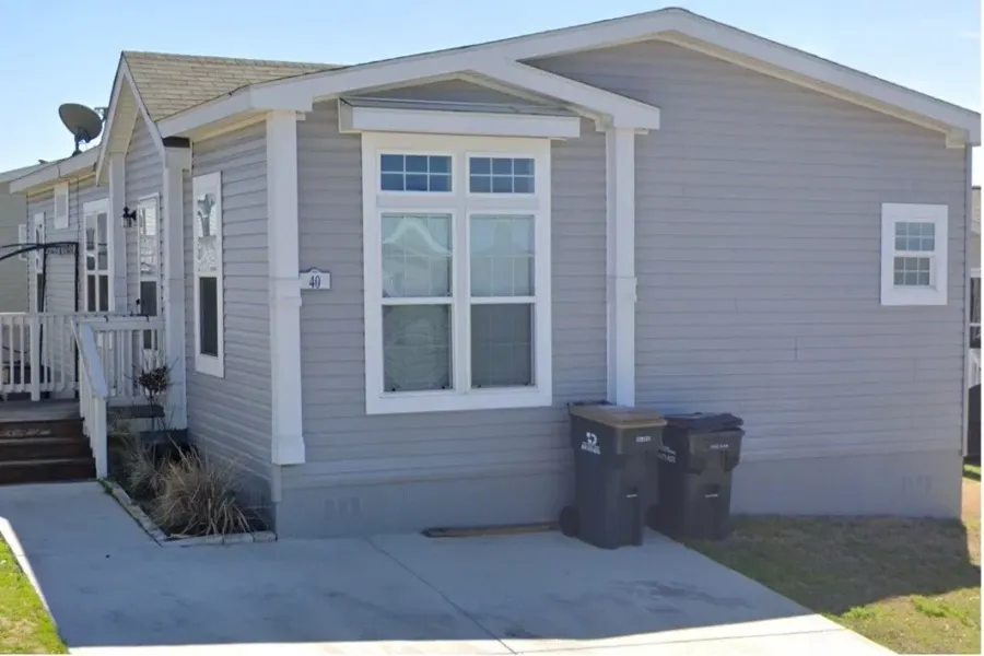 View of side of home featuring crawl space, a shingled roof, and a deck