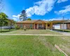 Ranch-style house with a carport, a front yard, and brick siding