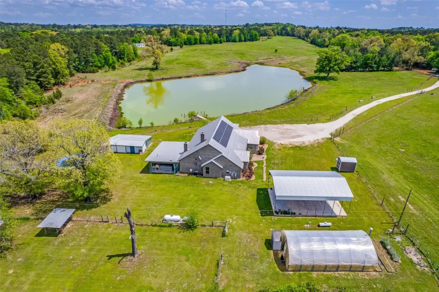 View of home with 3 acre pond, Greenhouse, RV pad and storage shed with HVAC