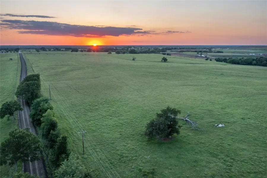 Expansive green acreage with a prominent sunset backdrop