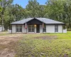 Contemporary ranch-style exterior featuring white brick siding and a contrasting black roofline