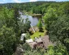 Aerial property encompassing a serene lakefront, mature tree coverage, and a private dock